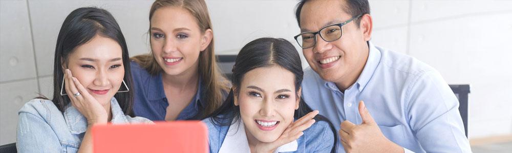 young women and father smiling in front of tablet