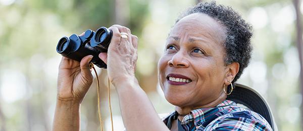 woman holding binoculars - welcome to retirement